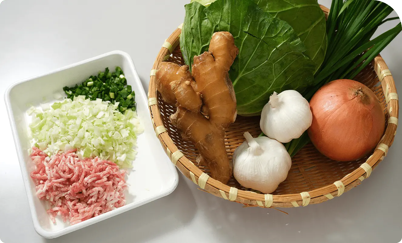 新鮮な野菜と豚ひき肉を並べた調理前の食材写真