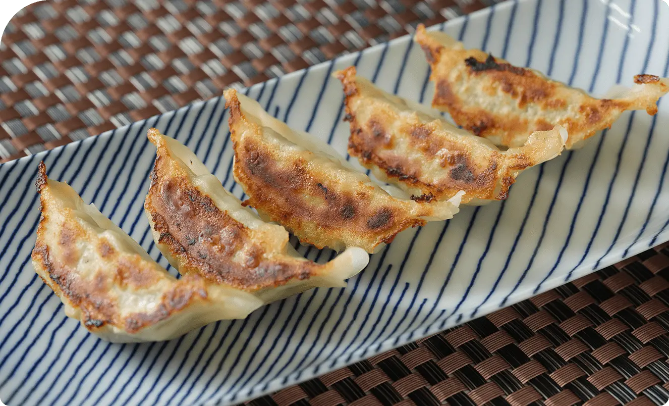 皿に盛られた焼き目のきれいな餃子の写真